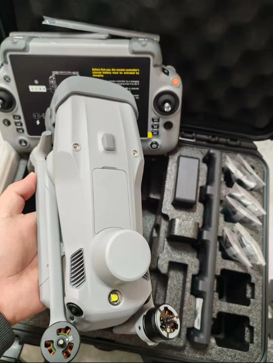Folded DJI Matrice 4T held above an open case with controller behind it