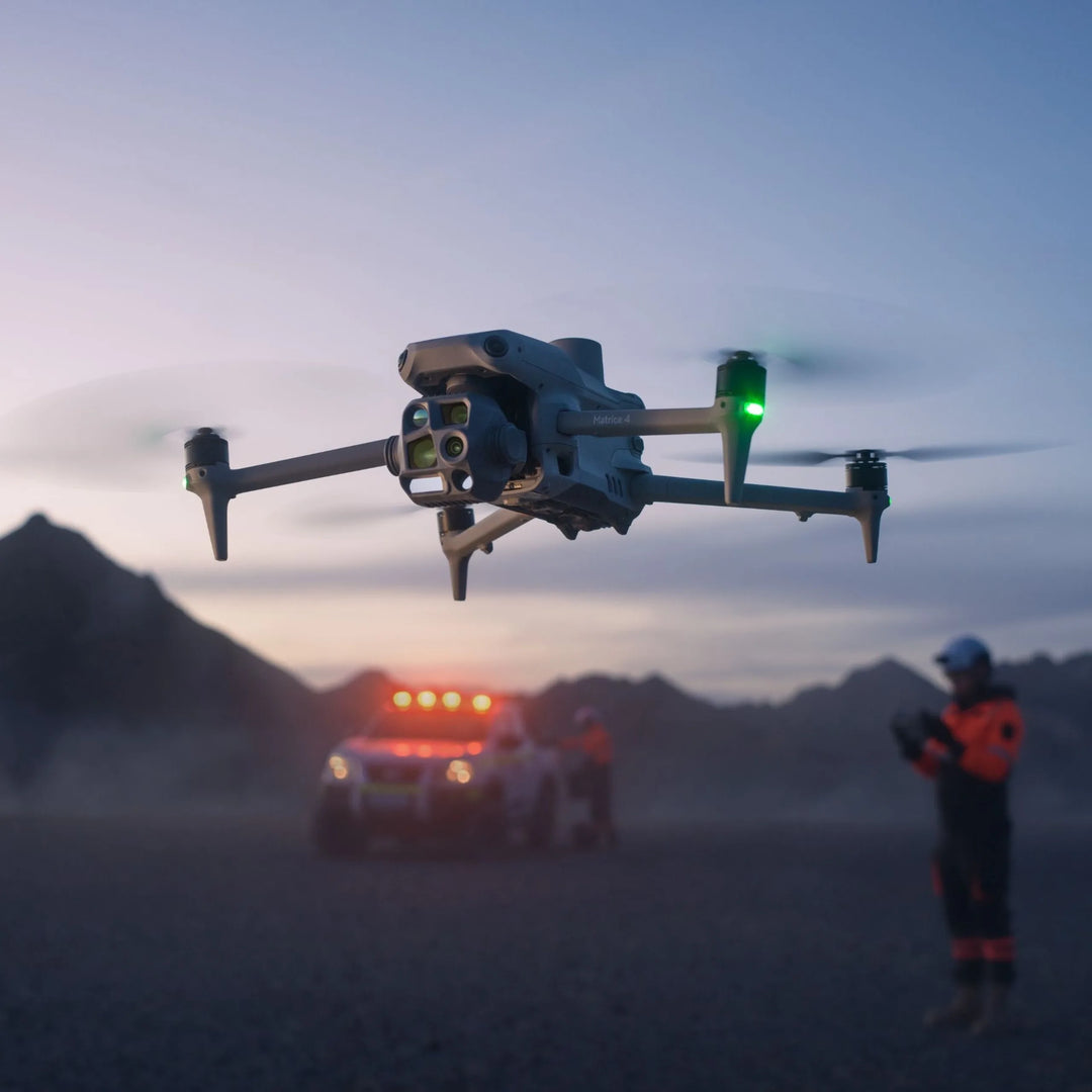 DJI Matrice 4T flying near an emergency vehicle and responder at dusk